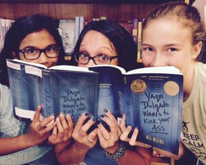 A group of friends reads 'Yaqui Delgado Wants to Kick Your Ass' by Meg Medina