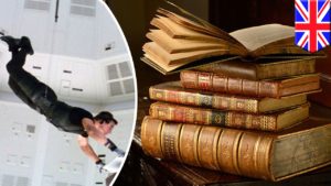 A man rappels from a ceiling to a stack of books. Dramatization.