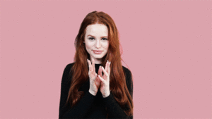 A girl rubs her hands together very evilly.