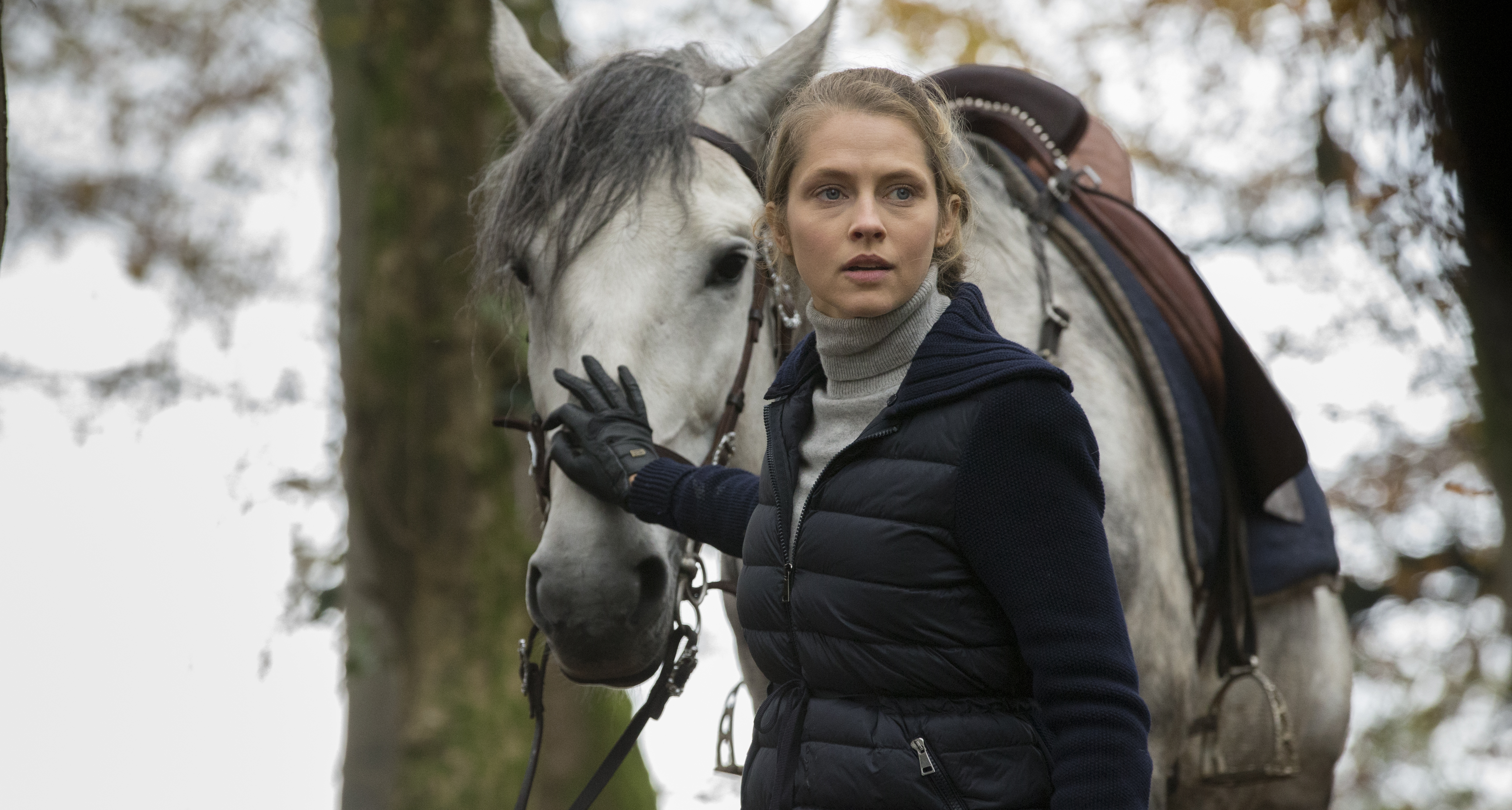 Teresa Palmer as Diana Bishop with hand on the nose of white horse