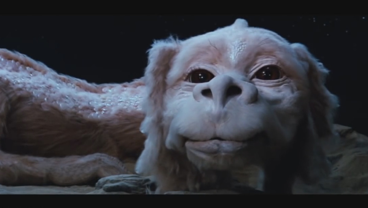 Falkor looks upon the viewer as he lies down on the desert sands in the movie adaptation of the Neverending Story