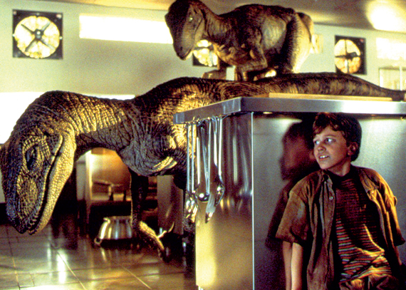 Tim Murphy (Joseph Mazzello) hides from two raptors in the film 