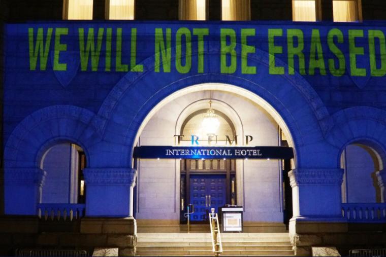 Projection onto a building reading "We will not be erased"