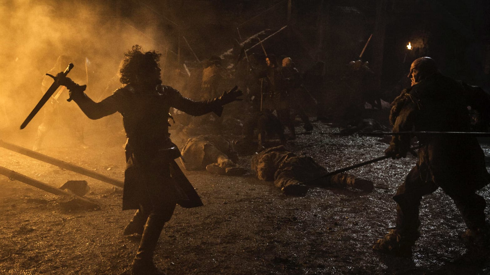 Jon Snow faces off against wildling attackers amidst the flaming assault on a castle