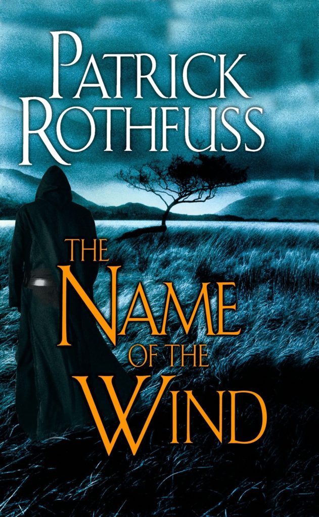 A cloaked figure stands on a field of grass against a black sky