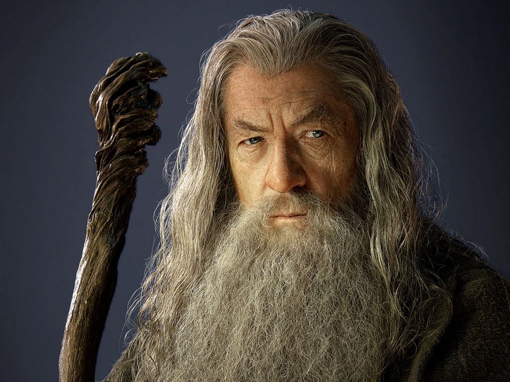 Gandalf, the robed wizard with a staff, stands with a fierce expression