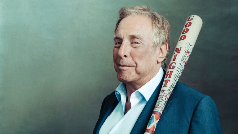 Charles Rovan of Atlas Entertainment stands before a backdrop with a baseball bat