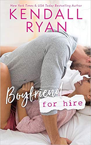 A man smiling sits on top of a woman in bed