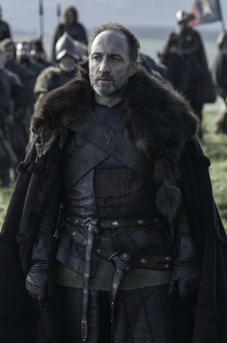 Roose Bolton stands on a grassland dressed in black leathers and fur lined cloak