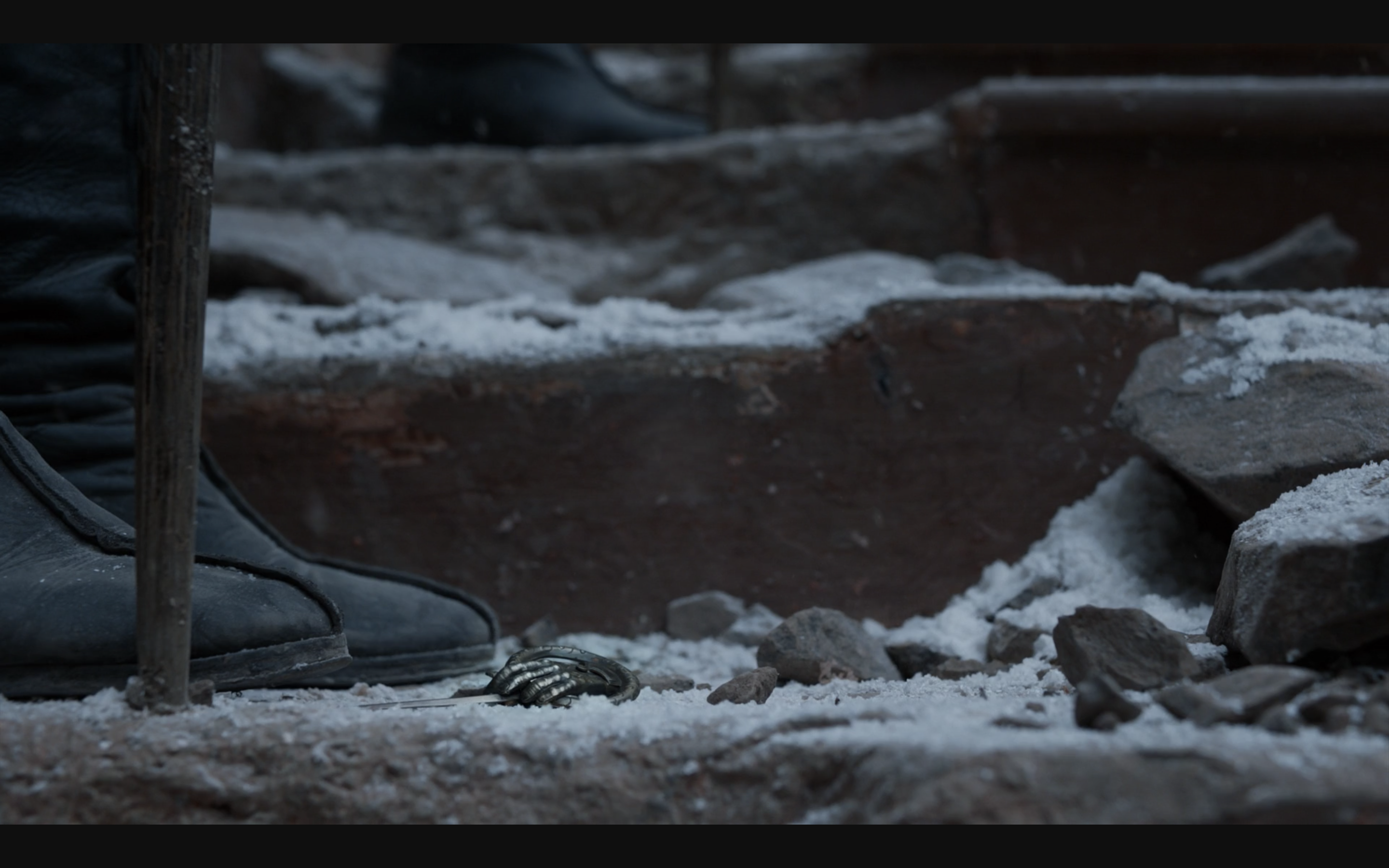 Hand of the Queen pin laying in the ashes