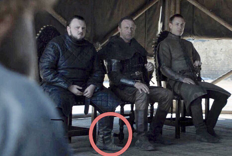 A water bottle sits underneath one of the council lord's legs during the meeting in GOT