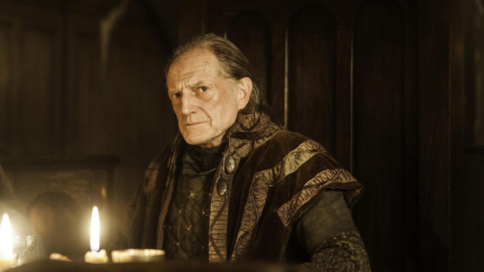 Walder Frey sits at a dimly lit dinner table