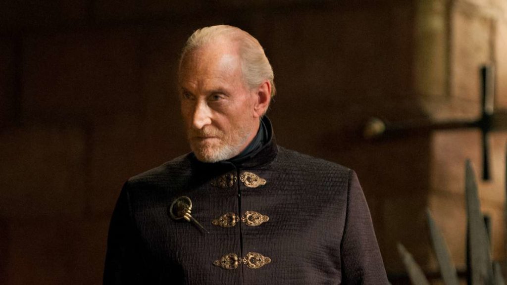 Tywin Lannister stands with regal authority in a red tunic 
