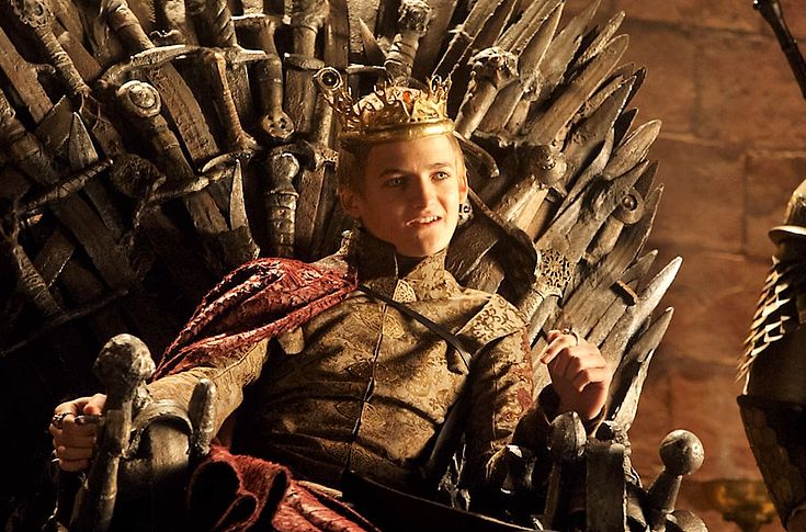 Joffrey Lannister sits on the iron Throne with a smug expression