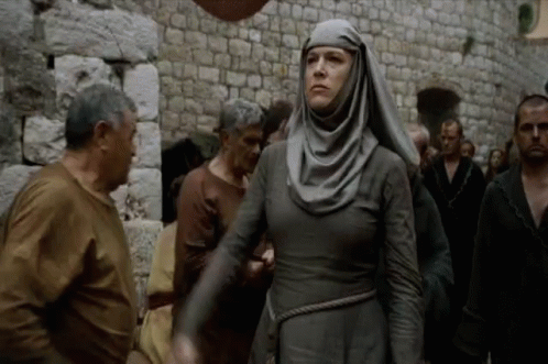 A nun-like figure walking through the streets ringing her bell and yelling 'Shame!'