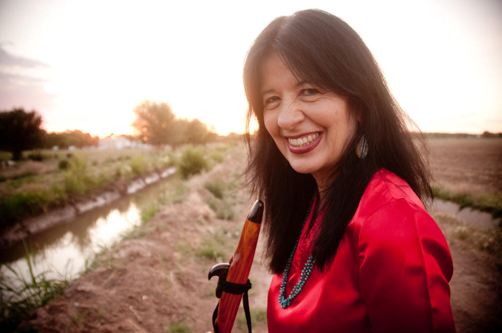 A Native American Woman stands on a lakeshore