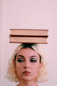 Blonde woman balancing books on her head