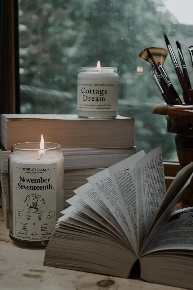 image of a book opened on a table surrounded by candles