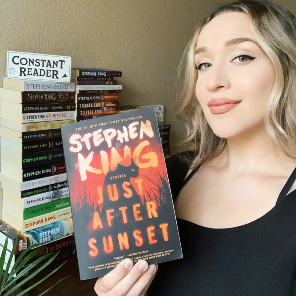 Selfie of a woman holding a book to show off the book cover