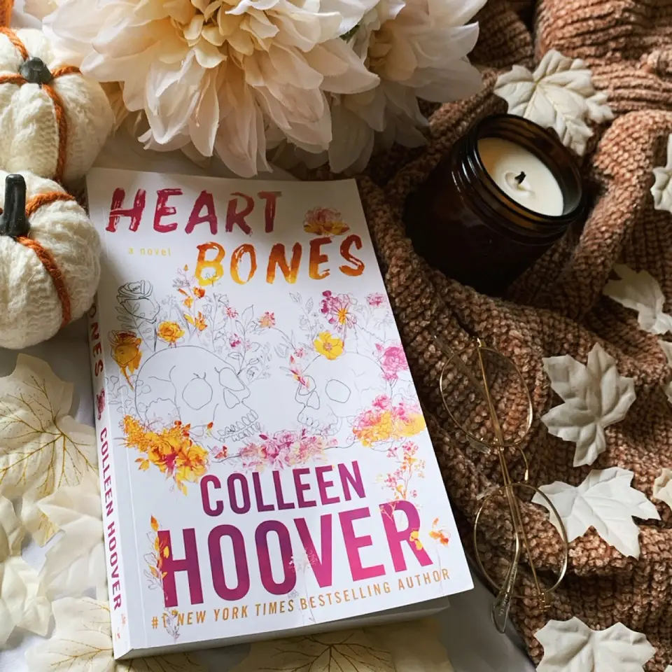 Image of a book on a table next to flowers and candles