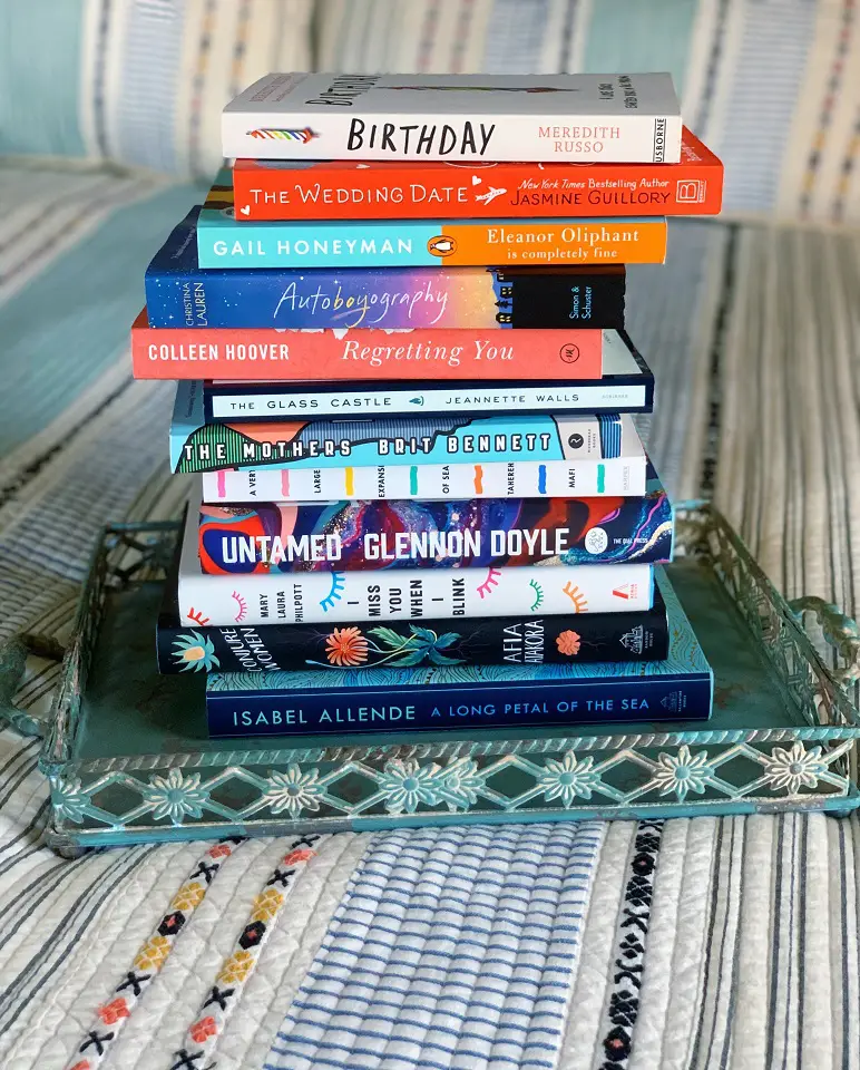 A stack of books sitting on a sofa